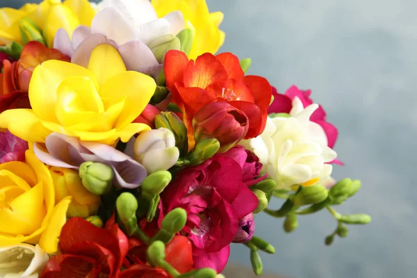 Красиві яскраві весняні квіти фрезії на кольоровому фоні, крупним планом — стокове фото
