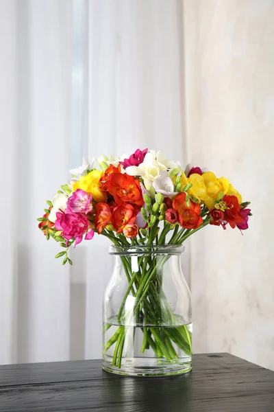 Vase avec bouquet de fleurs de printemps freesia sur la table dans la chambre — Photo