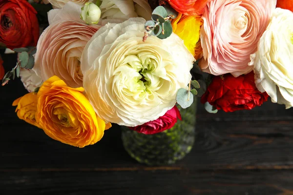 Букет з красивими яскравими квітами рунункули на темному столі, вид зверху — стокове фото