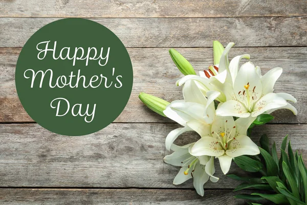 Szép liliom virágok és szöveg Boldog anyák napja, a fából készült háttér, felülnézet — Stock Fotó