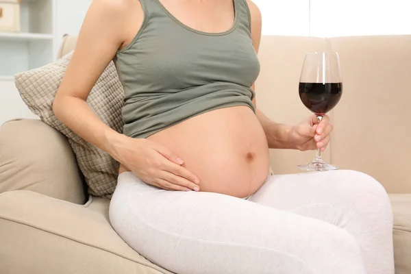 Pregnant woman with glass of red wine at home. Alcohol addiction — Stock Photo, Image