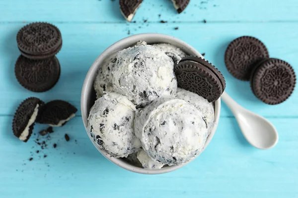 Flat lay composition with bowl of ice cream and crumbled chocolate cookies on wooden background — Stock Photo, Image