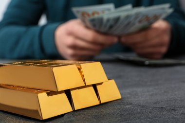 Yığılmış altın çubuklar ve adam masada para sayma, closeup. Metin alanı