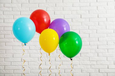 Tuğla duvara yakın parlak balonlar. Kutlama zamanı