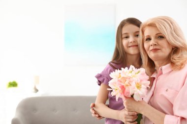 Küçük kızı evde olgun annesini tebrik, metin için boşluk. Mutlu anneler günü