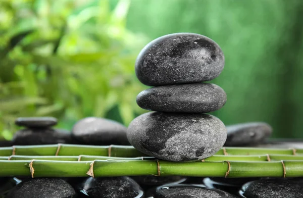 Zen stones on bamboo against blurred background — Stock Photo, Image