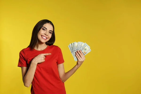 Junge Frau mit Geld auf farbigem Hintergrund. Raum für Text — Stockfoto