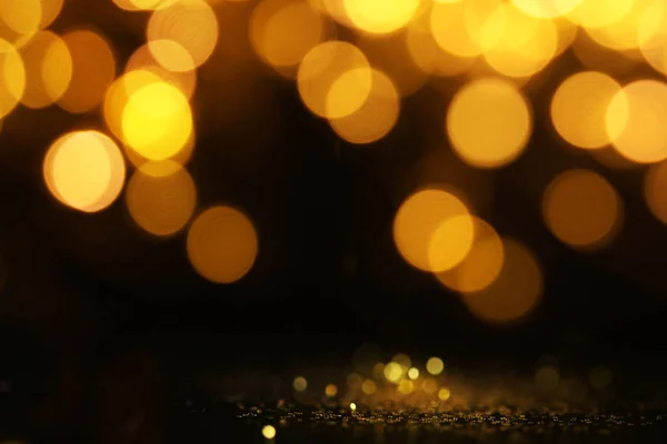 Gouden glitter met bokeh effect op zwarte achtergrond — Stockfoto