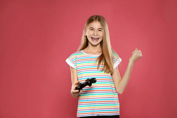 Adolescente jugando videojuegos con controlador sobre fondo de color —  Fotos de Stock