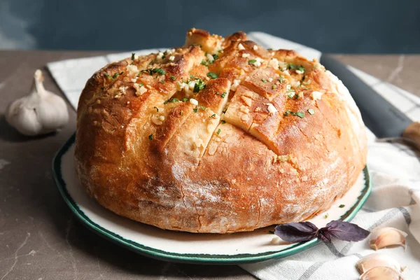 Тарелка с вкусным домашним чесночным хлебом на столе — стоковое фото