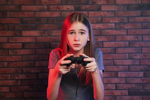 Adolescente jugando videojuegos con controlador cerca de la pared de ladrillo —  Fotos de Stock