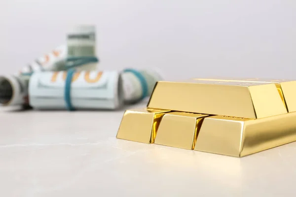 Shiny gold bars and dollar rolls on table. Space for text