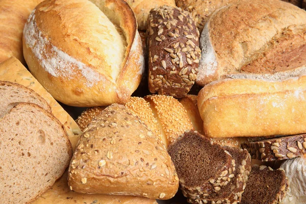 Diferentes tipos de pan como fondo, primer plano — Foto de Stock