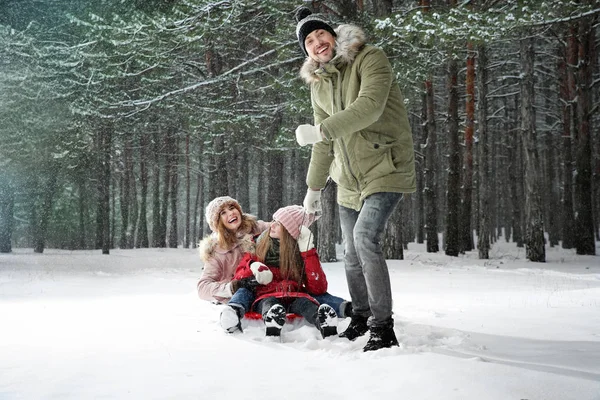 Lycklig familj kälkåkning i skog snö dag — Stockfoto