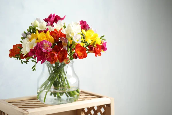 Букет весняних квітів фрезії у вазі на світлому фоні. Простір для тексту — стокове фото