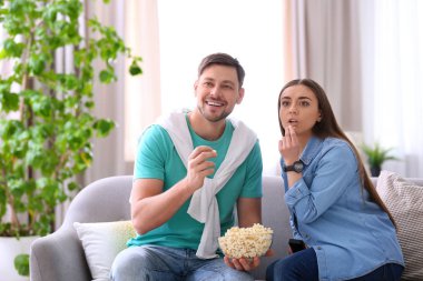Oturma odasında patlamış mısır ile film izlerken Çift