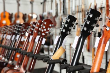 Row of different guitars in music store, closeup clipart