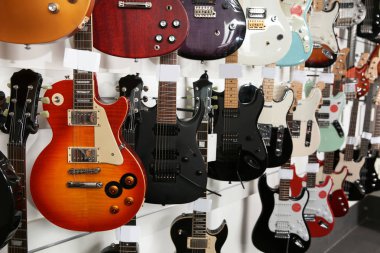 Müzik mağazasında farklı gitarların satırları