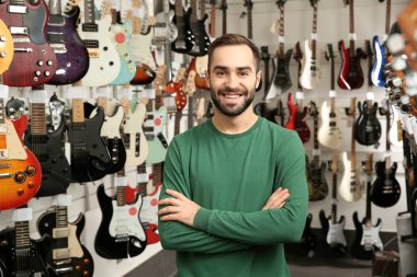 Müzik mağazasında gitar yakın genç dükkan asistanı