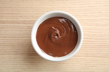 Ahşap arka planda tatlı çikolata krem ile kase, üst görünüm