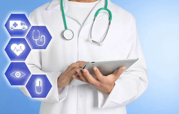 Médico con estetoscopio y tableta sobre fondo de color, primer plano. Servicio médico en línea —  Fotos de Stock