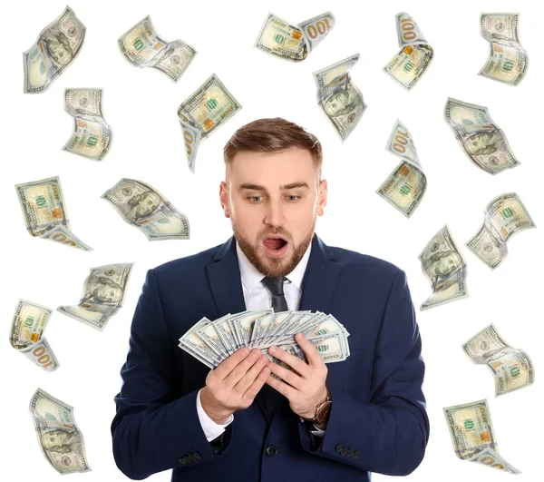 Portrait of young businessman with money and flying American dollars on white background — Stock Photo, Image