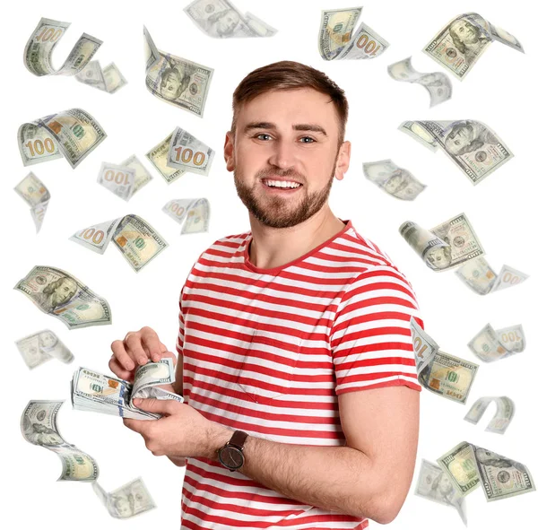Portrait of happy young man with money and flying American dollars on white background — Stock Photo, Image