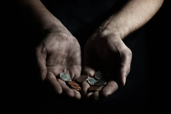Pobre hombre con monedas sobre fondo oscuro, primer plano — Foto de Stock