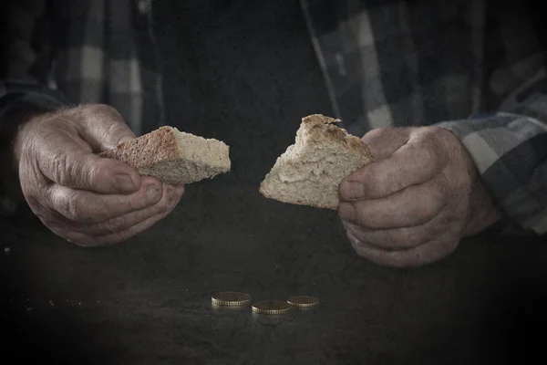 Poor senior man with bread at table, closeup — Stock Photo, Image