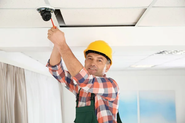 Elektriker med skruvmejsel reparera Cctv kamera inomhus — Stockfoto