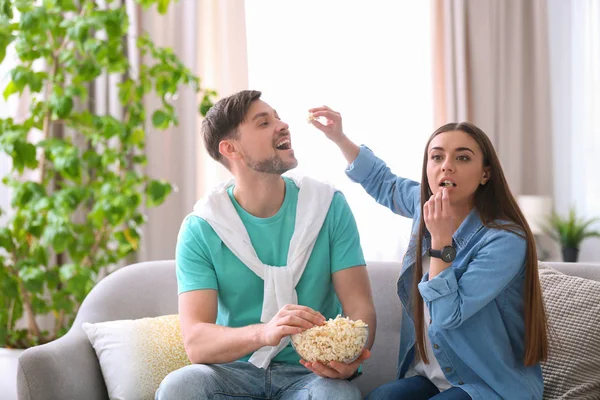 Casal assistindo filme com pipocas na sala de estar — Fotografia de Stock