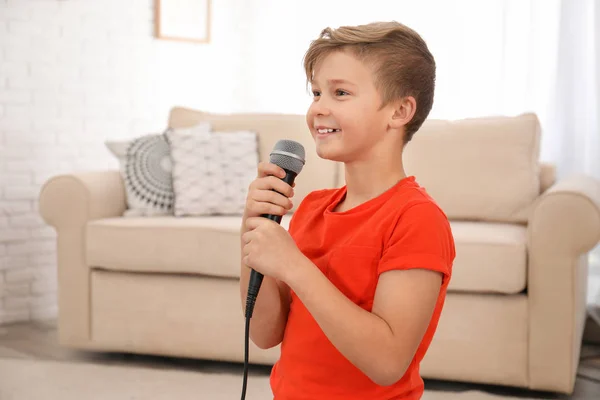 Rapaz bonito com microfone na sala de estar — Fotografia de Stock