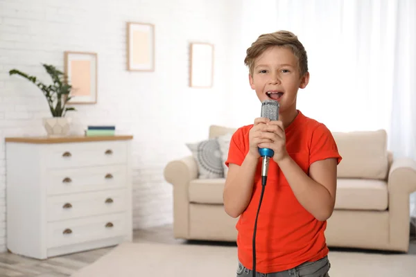 Garoto bonito cantando em microfone em casa — Fotografia de Stock