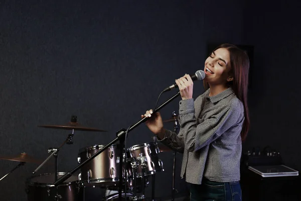Młoda piosenkarka z mikrofonem nagrywanie piosenki w Studio. Miejsce na tekst — Zdjęcie stockowe