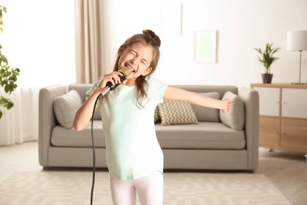 Jolie fille drôle avec microphone dans le salon — Photo