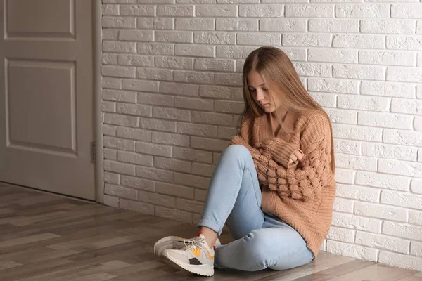 Menina adolescente perturbado sentado sozinho no chão perto da parede — Fotografia de Stock