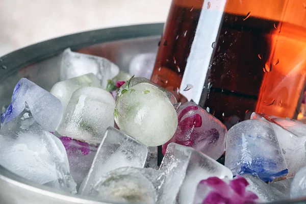 Cubos de gelo florais e garrafa de champanhe em balde, close-up — Fotografia de Stock