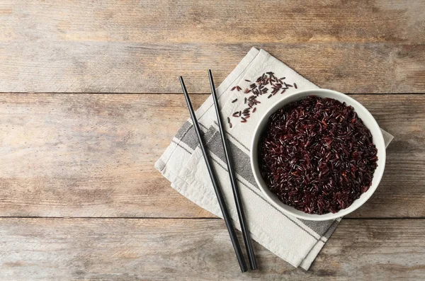 Composición plana con plato de arroz integral hervido y espacio para texto sobre fondo de madera — Foto de Stock