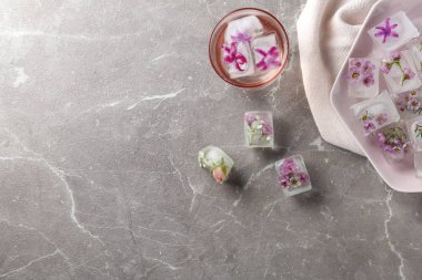 Düz masa üzerinde çiçek buz küpleri ile kompozisyon yatıyordu. Metin alanı