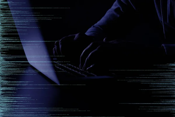 Silueta oscura de ciberdelincuente piratería informática detrás de símbolos digitales, primer plano —  Fotos de Stock