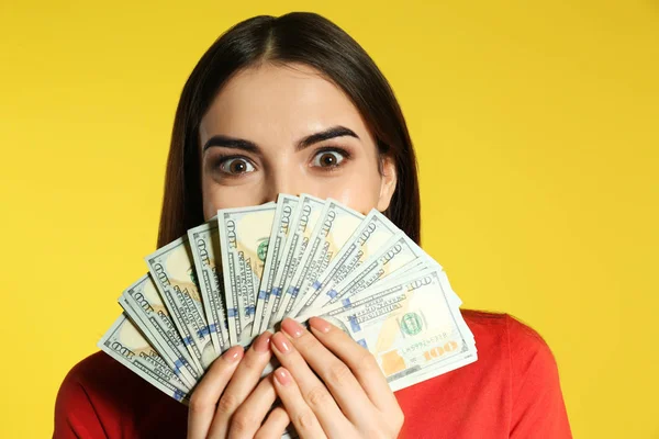 Junge Frau mit Geld auf farbigem Hintergrund — Stockfoto