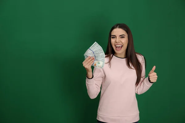 Young woman with money on color background