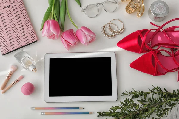 Flat lay composition with tablet and accessories on light background, space for design. Blogger's workplace