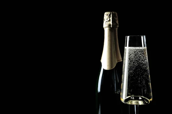 Bouteille et coupe de champagne sur fond noir, espace texte — Photo