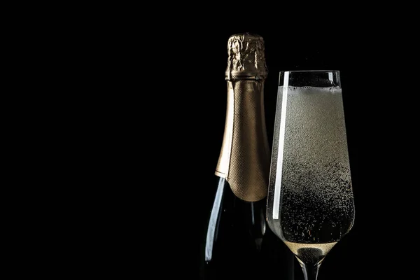 Fles en glas champagne op zwarte achtergrond, ruimte voor tekst — Stockfoto