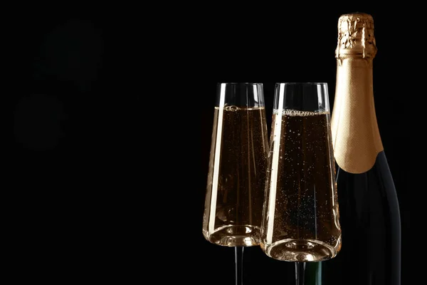 Fles en glazen champagne op zwarte achtergrond, ruimte voor tekst — Stockfoto