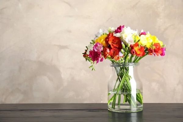 Bouquet of spring freesia flowers in vase on table. Space for text — Stock Photo, Image