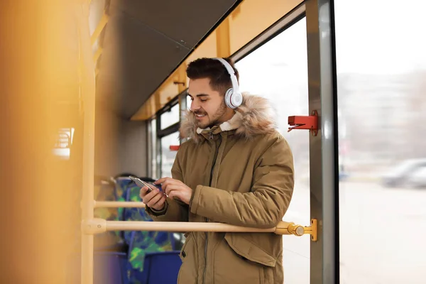 Ung man lyssnar på musik med hörlurar i kollektivtrafiken — Stockfoto