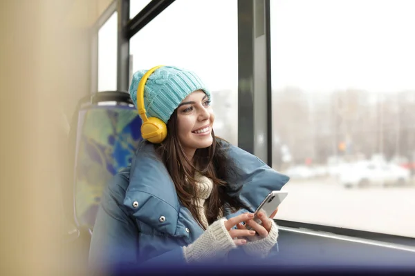 Mujer joven escuchando música con auriculares en el transporte público — Foto de Stock