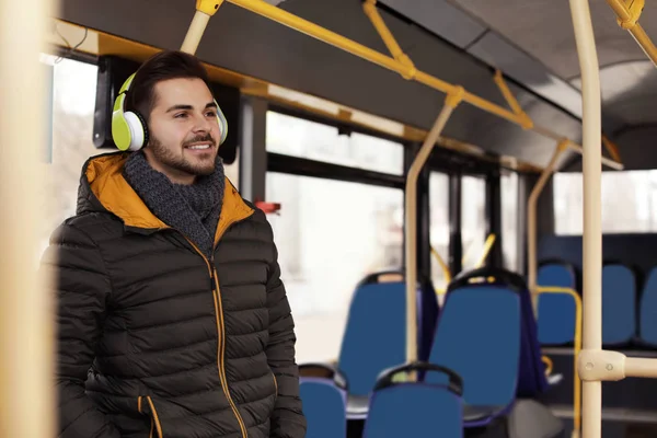 Jovem ouvindo música com fones de ouvido em transportes públicos — Fotografia de Stock